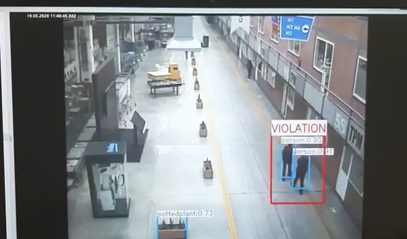 A violation was detected in the camera footage showing the surrounding items, people who did not follow the social distance.