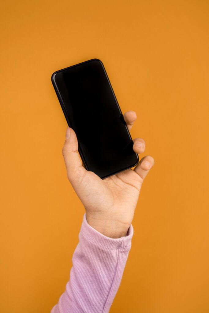 A person holds an apple iphone in her hand.