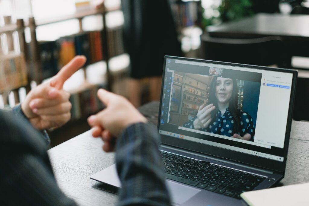 Bank employee communicating in sign language via video call with a deaf bank customer.