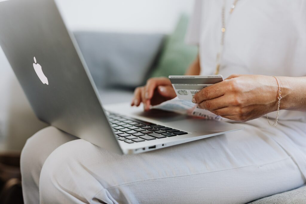 MacBook üzerinden e-ticaret alışverişini yapan ve kendi kredi kartıyla ödemesini yapan bir kadın müşteri.
